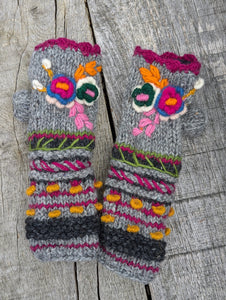 Grey handknitted wool fingerless mitts with bright embroidered flowers and textured knit details. Aster Fingerless Mitts, handmade in Nepal, fleece-lined.
